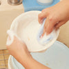Hands scrubbing a bowl with a soapy sponge
