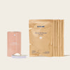A pink cylindrical container of Oxi Laundry Booster is next to white powder, with five brown paper refill packets labeled Blueland Oxi Laundry Booster Clear Skies, emphasizing zero-waste, all on a light background.