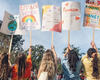 Women at women's march holding climate and feminism signs